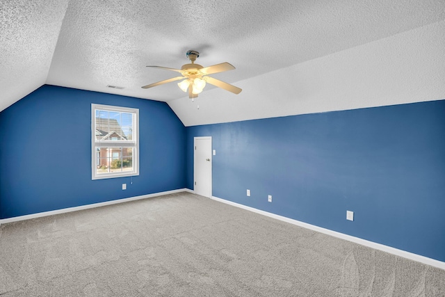 additional living space featuring a textured ceiling, ceiling fan, carpet, and lofted ceiling