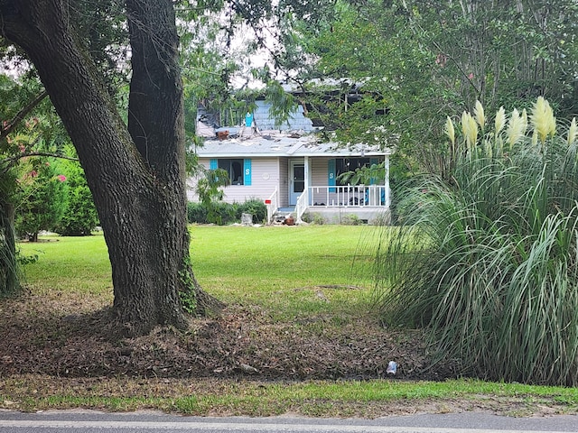 ranch-style house featuring a front yard and covered porch