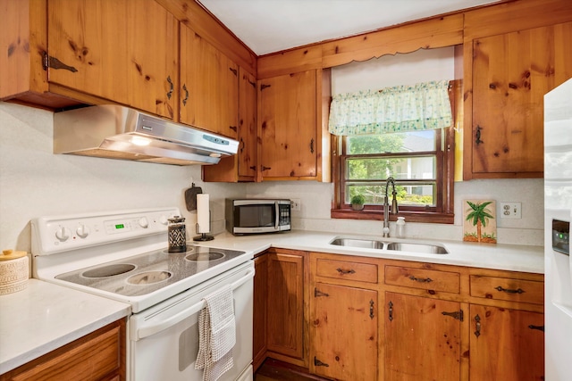 1900 Morgan Ave, North Charleston, SC 29406 - kitchen with white range with electric stovetop, under cabinet range hood, stainless steel microwave, and brown cabinets