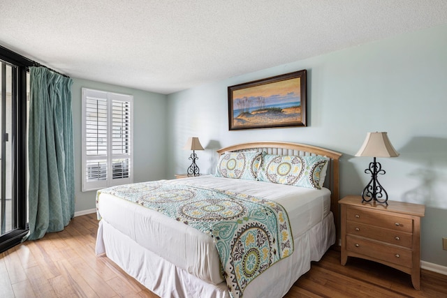 bedroom with hardwood / wood-style floors and a textured ceiling