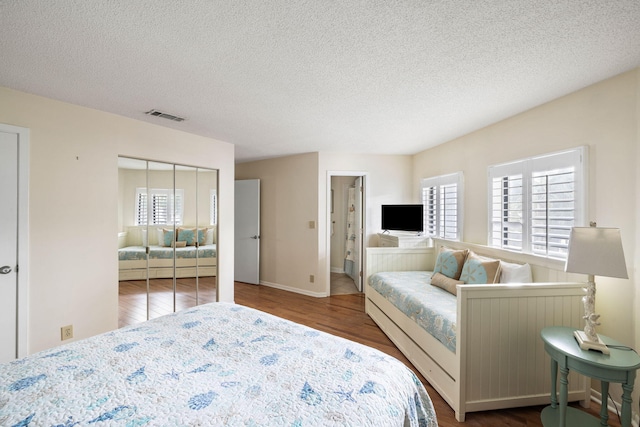 bedroom with hardwood / wood-style flooring, a closet, and a textured ceiling