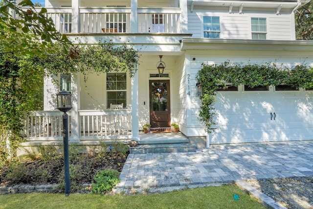 entrance to property with covered porch and a garage