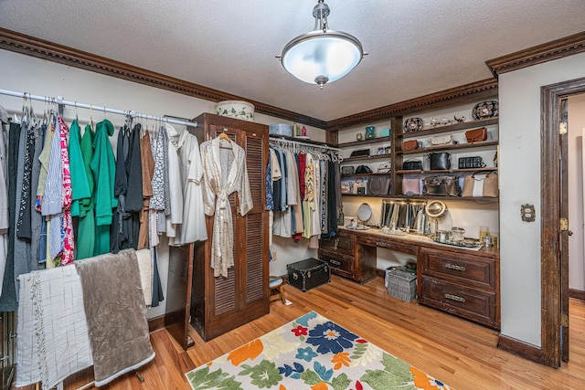 spacious closet featuring built in desk and light wood-type flooring