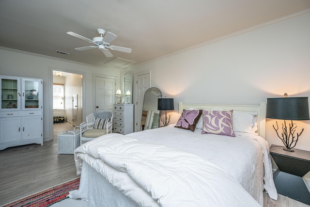 bedroom featuring hardwood / wood-style floors, crown molding, and ceiling fan