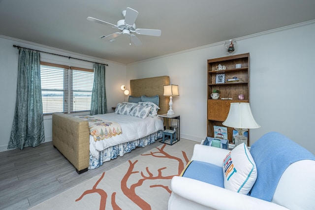 bedroom with crown molding, wood-type flooring, and ceiling fan