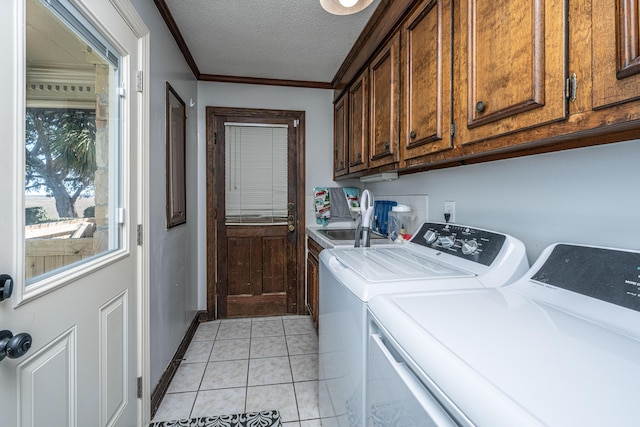 clothes washing area with light tile patterned floors, washer and clothes dryer, cabinets, ornamental molding, and a textured ceiling