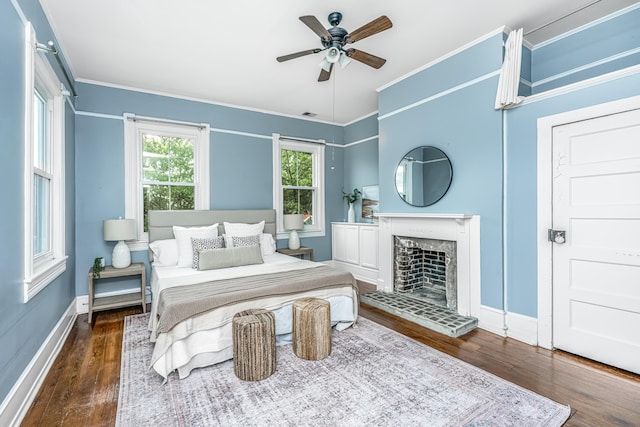 173 Fishburne St, Charleston, SC 29403 - bedroom with wood finished floors, ornamental molding, baseboards, a fireplace with raised hearth, and a ceiling fan