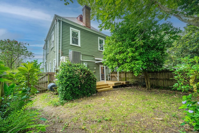 173 Fishburne St, Charleston, SC 29403 - back of house featuring a chimney, a wooden deck, a fenced backyard, and metal roof