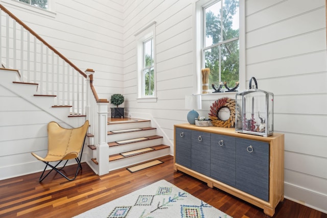 stairway featuring wood-type flooring and wooden walls