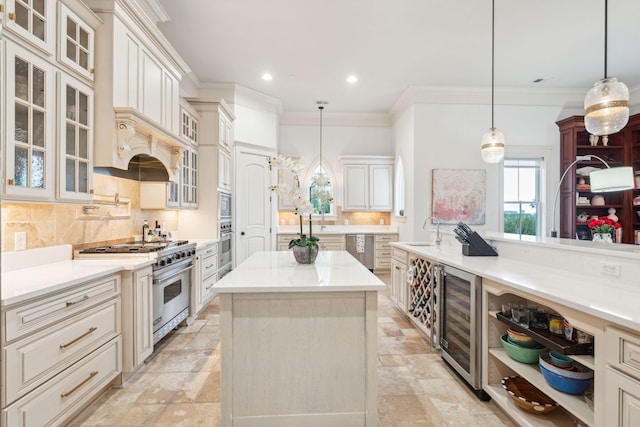 kitchen with pendant lighting, wine cooler, sink, an island with sink, and appliances with stainless steel finishes