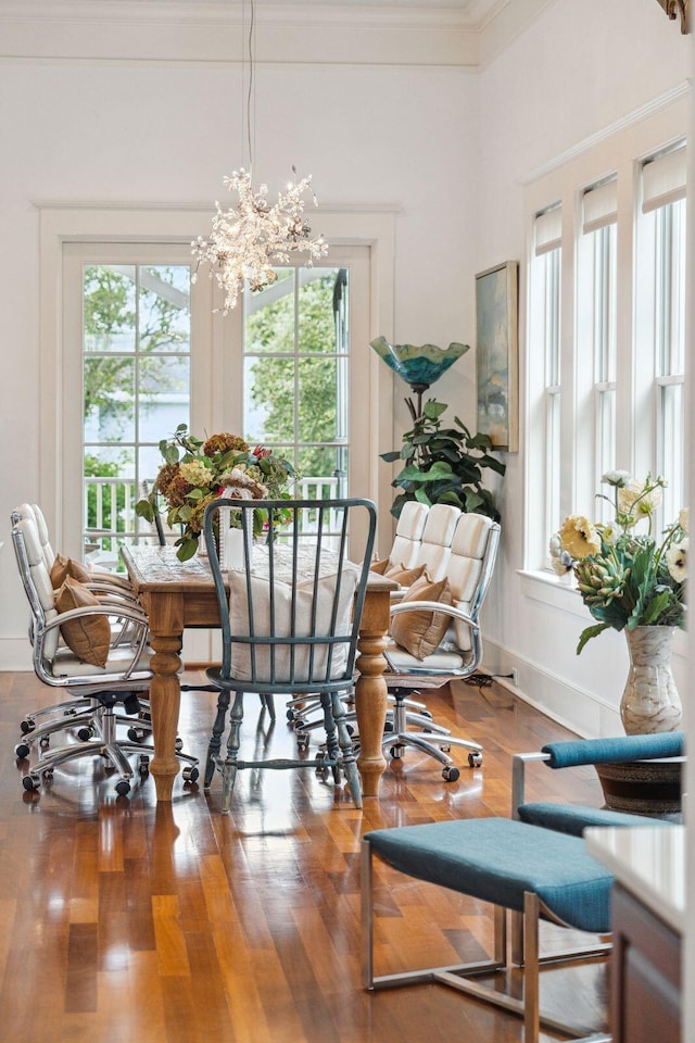 dining room with ornamental molding, a chandelier, and hardwood / wood-style floors