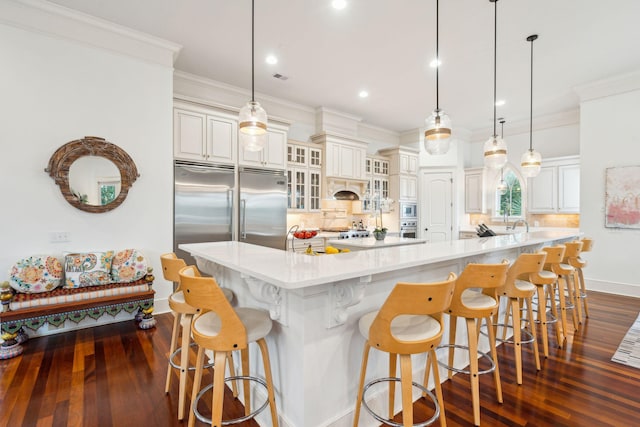 kitchen featuring a large island, a kitchen bar, and hanging light fixtures