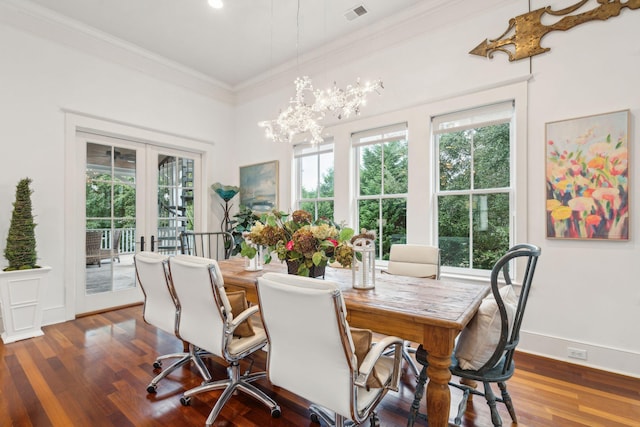 dining area featuring ornamental molding, an inviting chandelier, dark wood-type flooring, and french doors