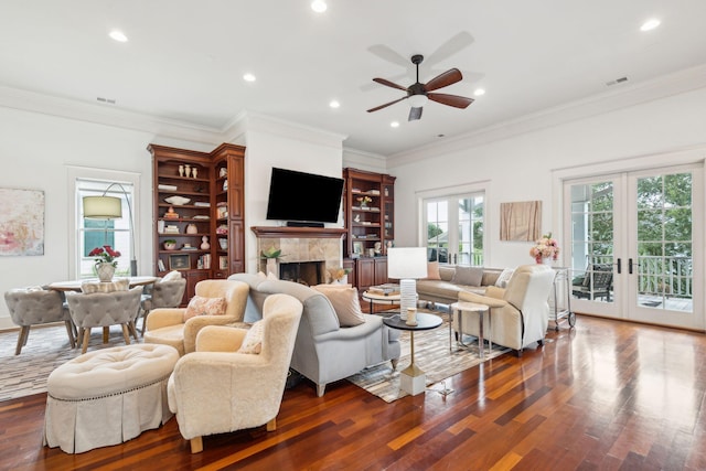 living room with ornamental molding, dark wood-type flooring, ceiling fan, and french doors