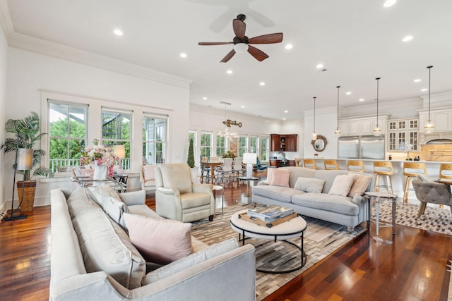 living room with ceiling fan with notable chandelier, ornamental molding, hardwood / wood-style floors, and sink