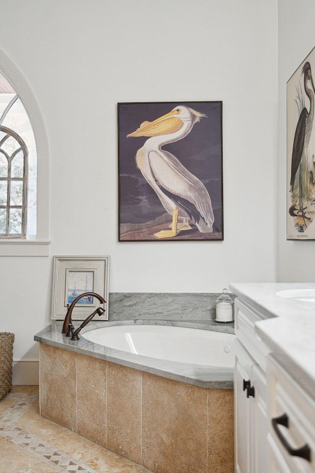 bathroom featuring tiled bath and vanity