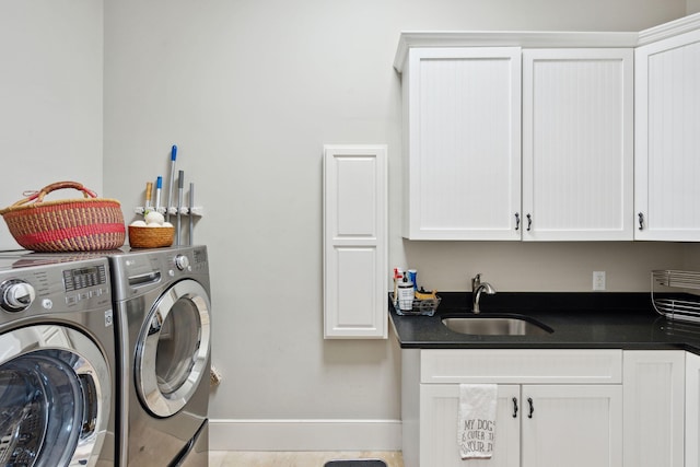 laundry area featuring light tile patterned floors, separate washer and dryer, cabinets, and sink