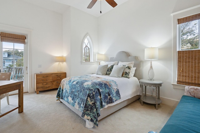 carpeted bedroom featuring multiple windows, access to outside, lofted ceiling, and ceiling fan