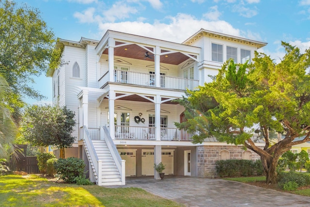 view of front of home featuring a balcony, a garage, ceiling fan, and covered porch