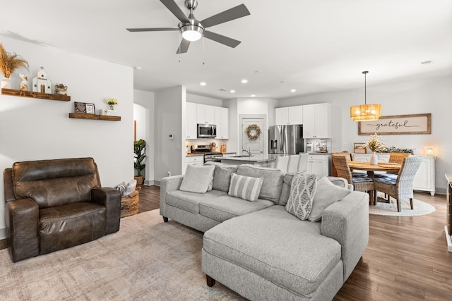404 Omaha Dr, Moncks Corner, SC 29461 - living room featuring wood finished floors, ceiling fan, recessed lighting, baseboards, and a chandelier