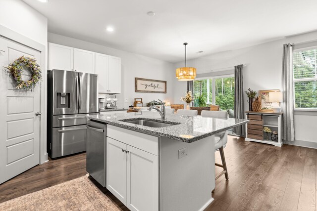 404 Omaha Dr, Moncks Corner, SC 29461 - kitchen with stainless steel appliances, a sink, a kitchen bar, light stone countertops, and dark wood-style floors