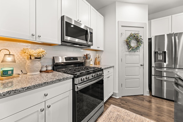 404 Omaha Dr, Moncks Corner, SC 29461 - kitchen with stainless steel appliances, dark wood-style flooring, white cabinets, and light stone countertops