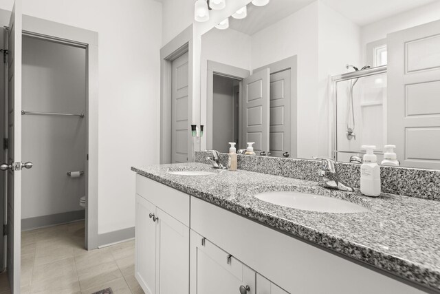 404 Omaha Dr, Moncks Corner, SC 29461 - bathroom with double vanity, toilet, an enclosed shower, tile patterned flooring, and baseboards