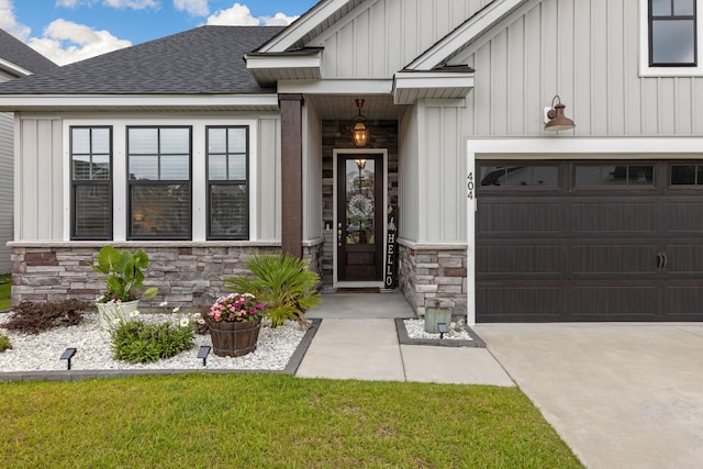 404 Omaha Dr, Moncks Corner, SC 29461 - view of exterior entry featuring board and batten siding, stone siding, a shingled roof, and concrete driveway
