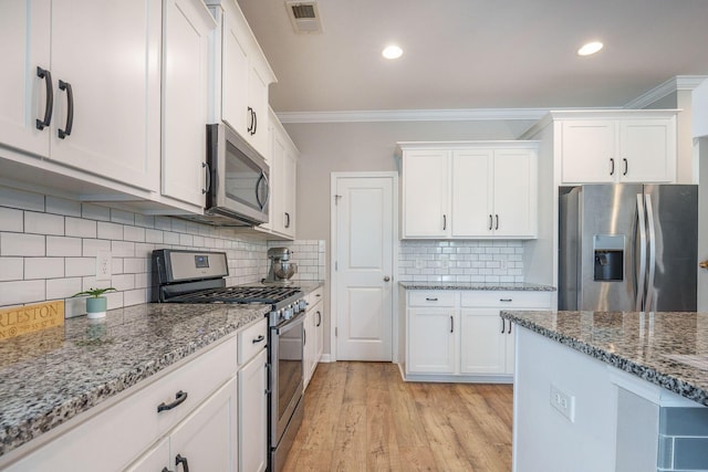 419 Whispering Breeze Ln, Summerville, SC 29486 - kitchen with crown molding, light stone countertops, stainless steel appliances, white cabinetry, and visible vents