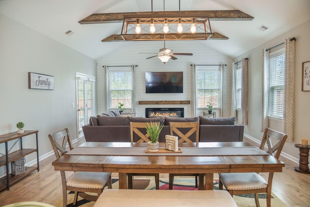 419 Whispering Breeze Ln, Summerville, SC 29486 - dining room with a large fireplace, a ceiling fan, light wood finished floors, and a wealth of natural light