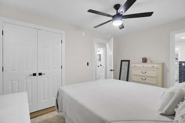 bedroom featuring a closet, ceiling fan, ensuite bathroom, and light wood-style floors