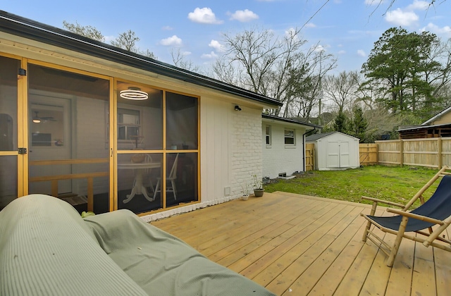 deck with fence, a yard, a sunroom, an outbuilding, and a storage unit