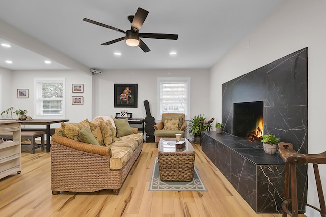 living area with recessed lighting, a ceiling fan, and wood finished floors