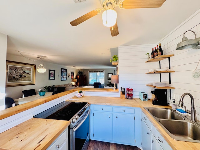 kitchen featuring electric range, a sink, open shelves, blue cabinetry, and a peninsula