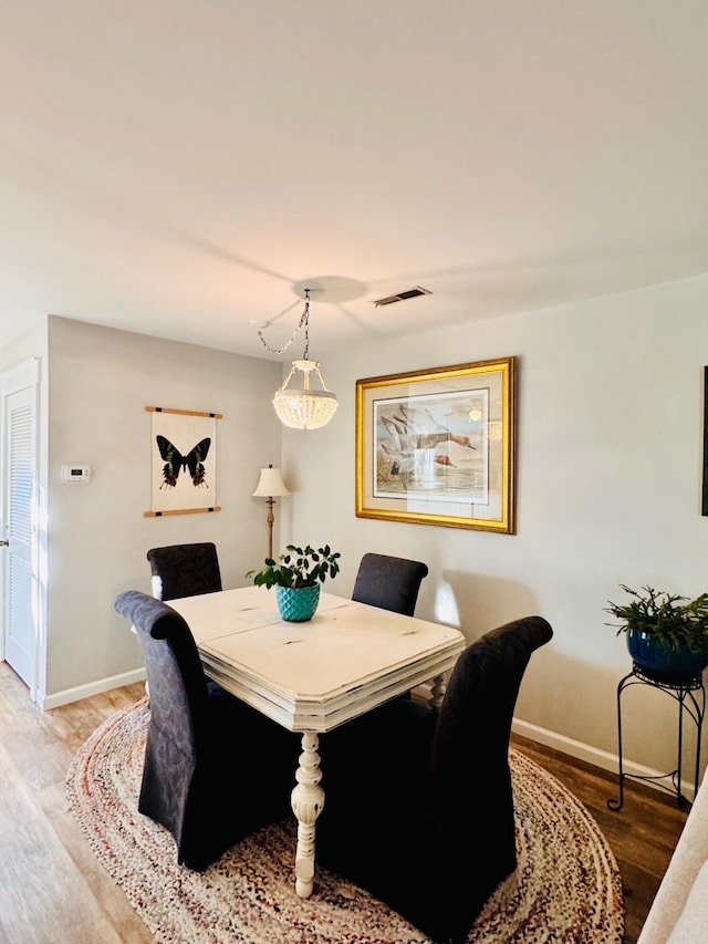 dining area with visible vents, wood finished floors, and baseboards