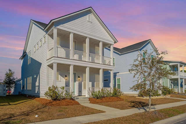 greek revival inspired property featuring a porch and a balcony