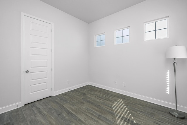 spare room with dark hardwood / wood-style flooring and a healthy amount of sunlight