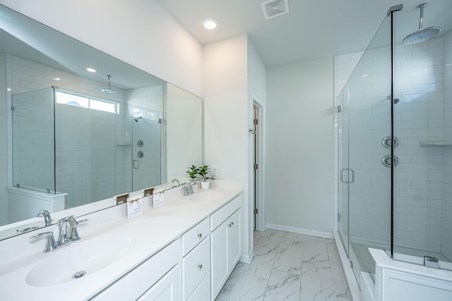 bathroom with a shower with shower door and vanity