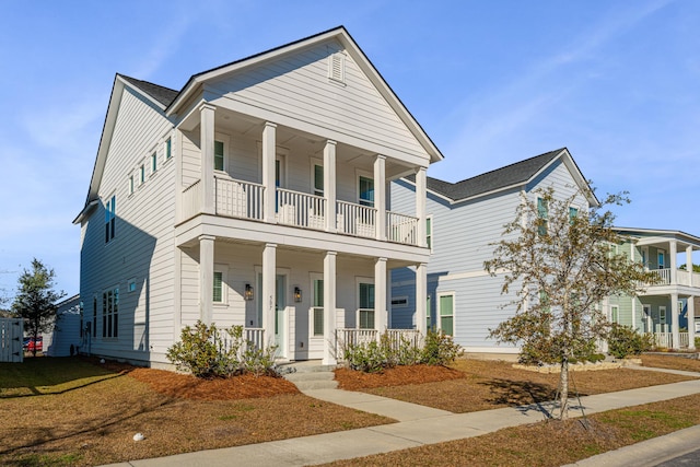 neoclassical home featuring covered porch and a balcony