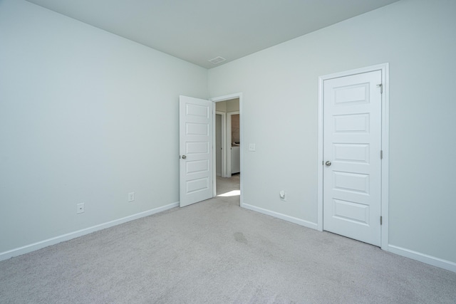 unfurnished room featuring light colored carpet