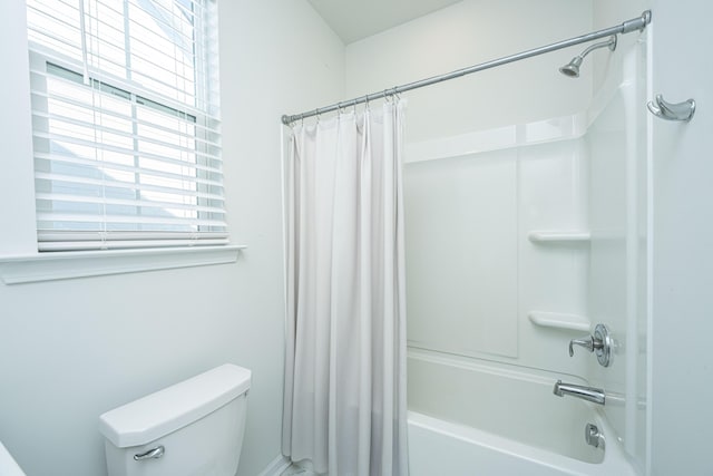 bathroom featuring shower / bathtub combination with curtain and toilet