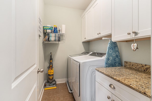 washroom featuring cabinets, separate washer and dryer, and dark tile patterned floors