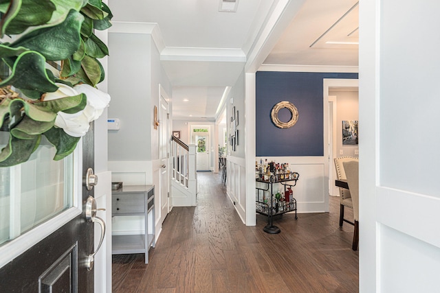 entryway with ornamental molding and dark hardwood / wood-style floors