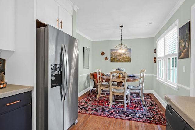 dining room featuring hardwood / wood-style flooring, crown molding, and a chandelier