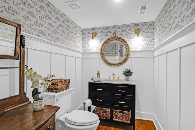 bathroom with toilet, vanity, and hardwood / wood-style flooring