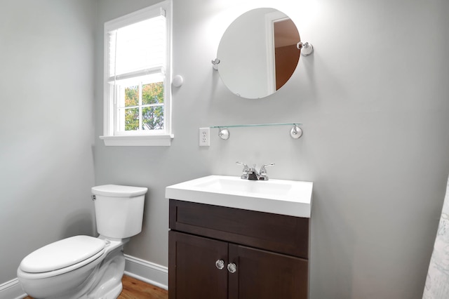 bathroom with hardwood / wood-style floors, vanity, and toilet