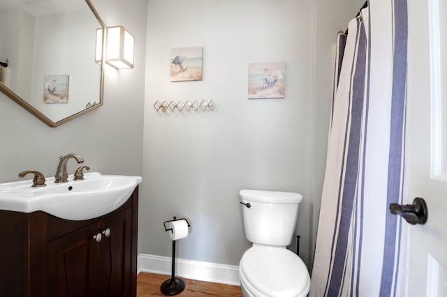 bathroom with hardwood / wood-style floors, vanity, and toilet