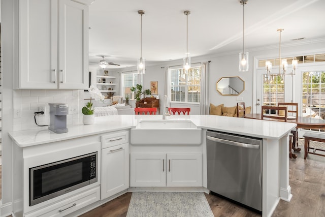 kitchen featuring ornamental molding, a sink, tasteful backsplash, appliances with stainless steel finishes, and light countertops