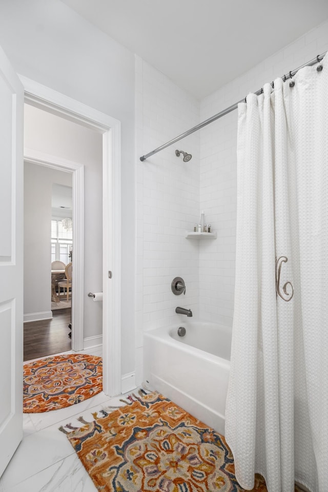 full bathroom featuring baseboards and shower / tub combo with curtain