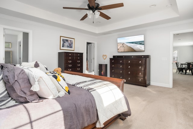 carpeted bedroom featuring a raised ceiling, crown molding, baseboards, and ceiling fan